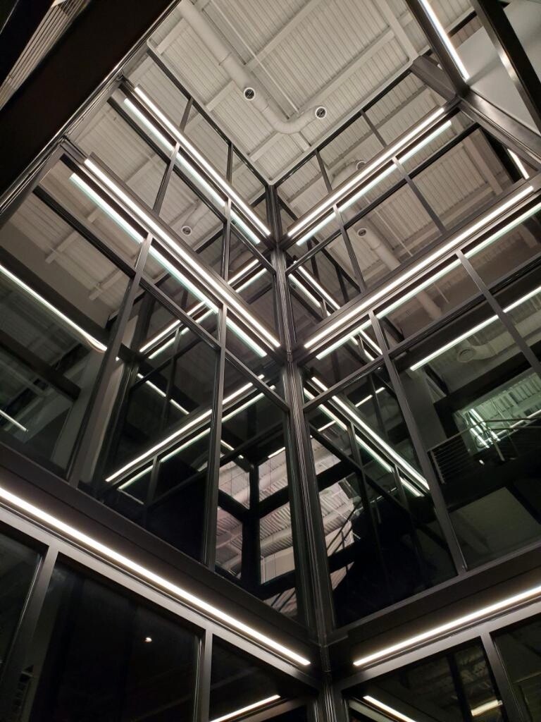 Mirrored architectural lighting column with eight-foot linear fixtures installed by Zach Moody